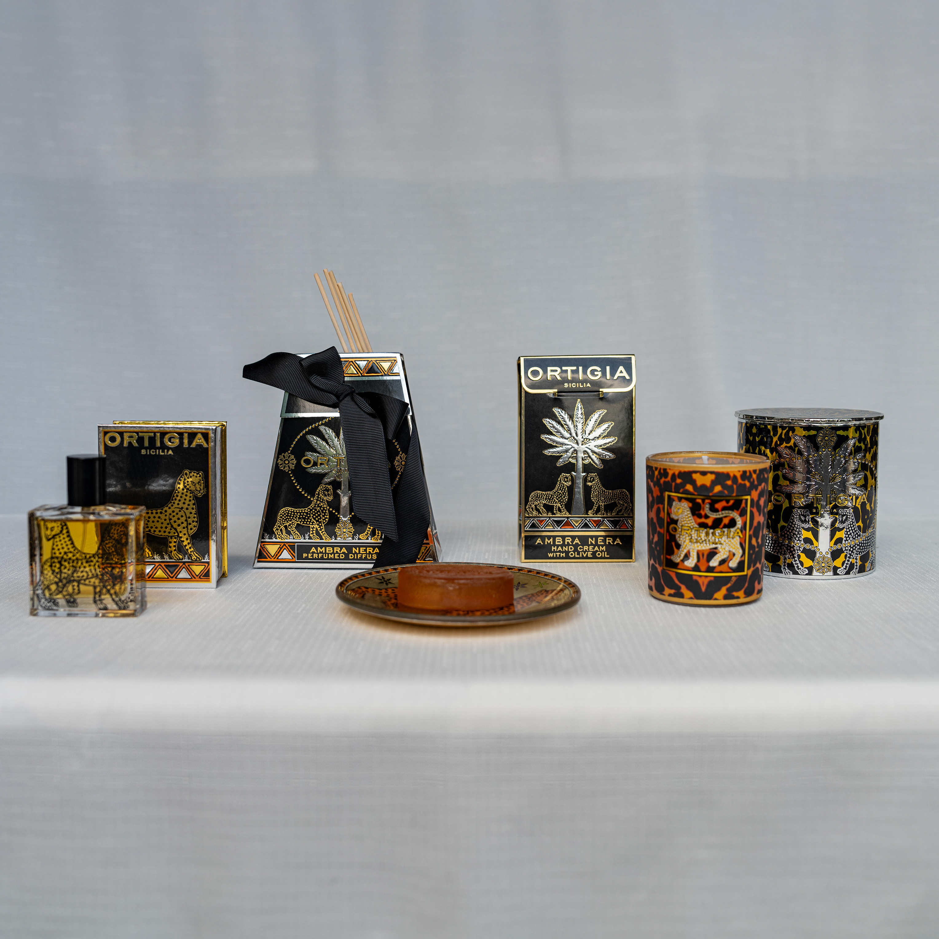 Ortigia amber diffuser in signature yellow tinted bottle with accompanying diffuser sticks