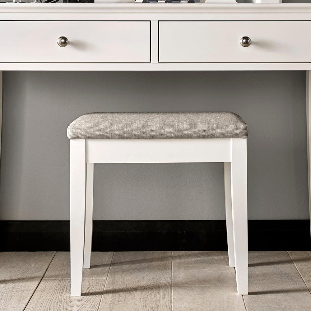 Bedroom stool in painted white upholstered with textured pebble grey fabric