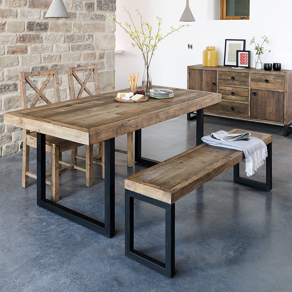 Reclaimed timber dining table in natural finish with industrial black metal legs