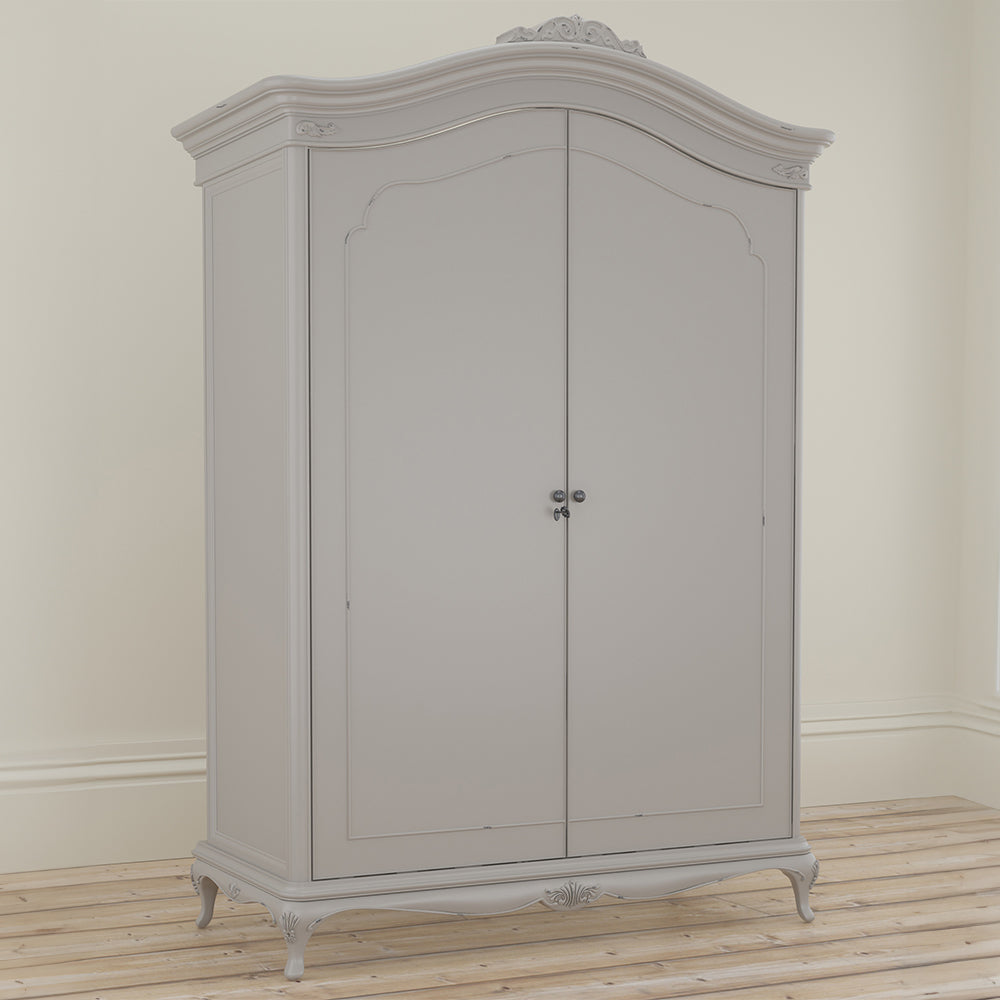 A closed soft grey wardrobe with curved top and ornate crown, featuring double doors and decorative legs