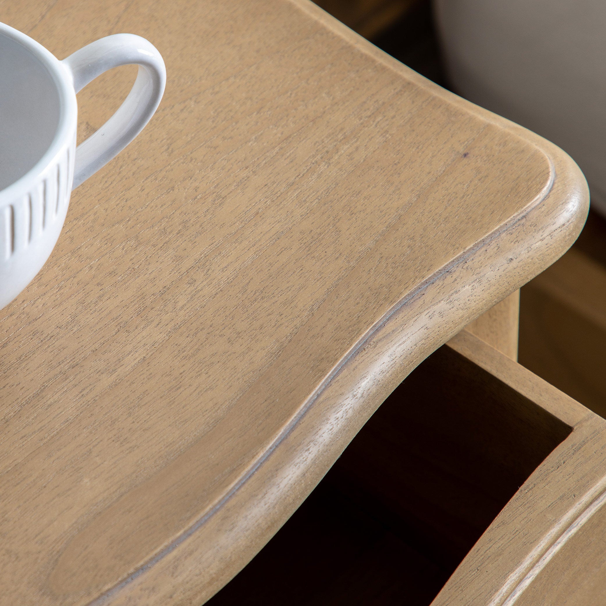 Mindy ash bedside table in weathered finish featuring dovetailed joints and hand carved sections