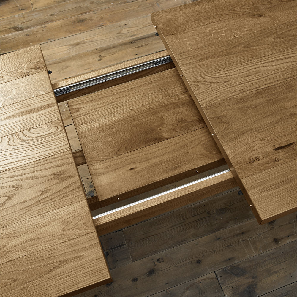 Rustic oak extending dining table with laminated oak tabletops and solid ash legs all in natural finish