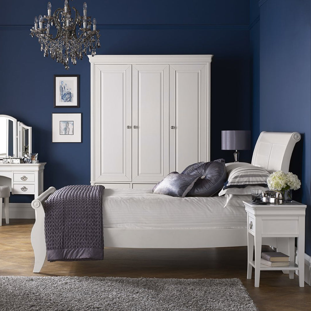 Wooden triple wardrobe in painted white finish with three accompanying bottom drawers and silver handles