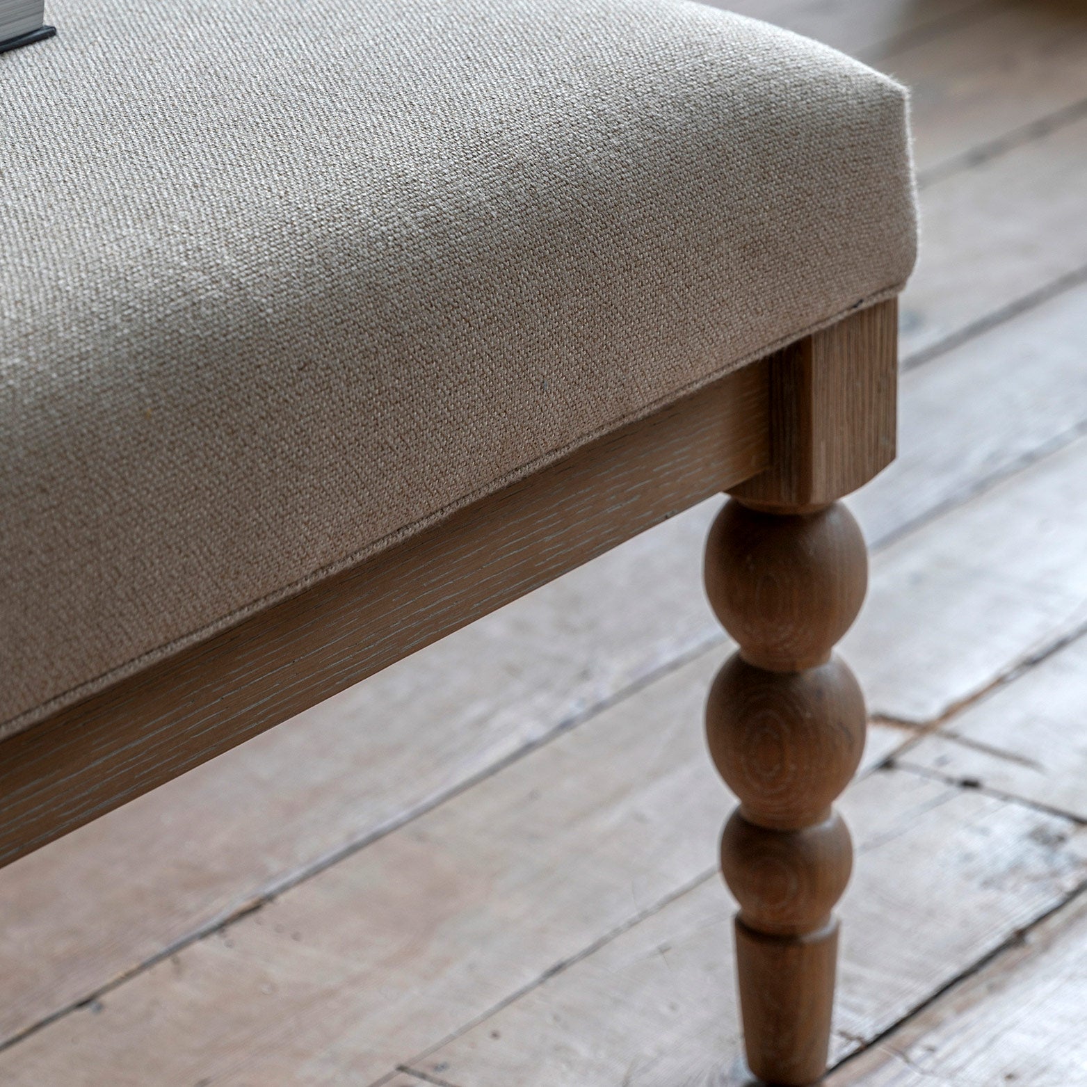 Oak coffee table in lime wash finish, handcrafted bobbing detailed legs and upholstered neutral fabric top