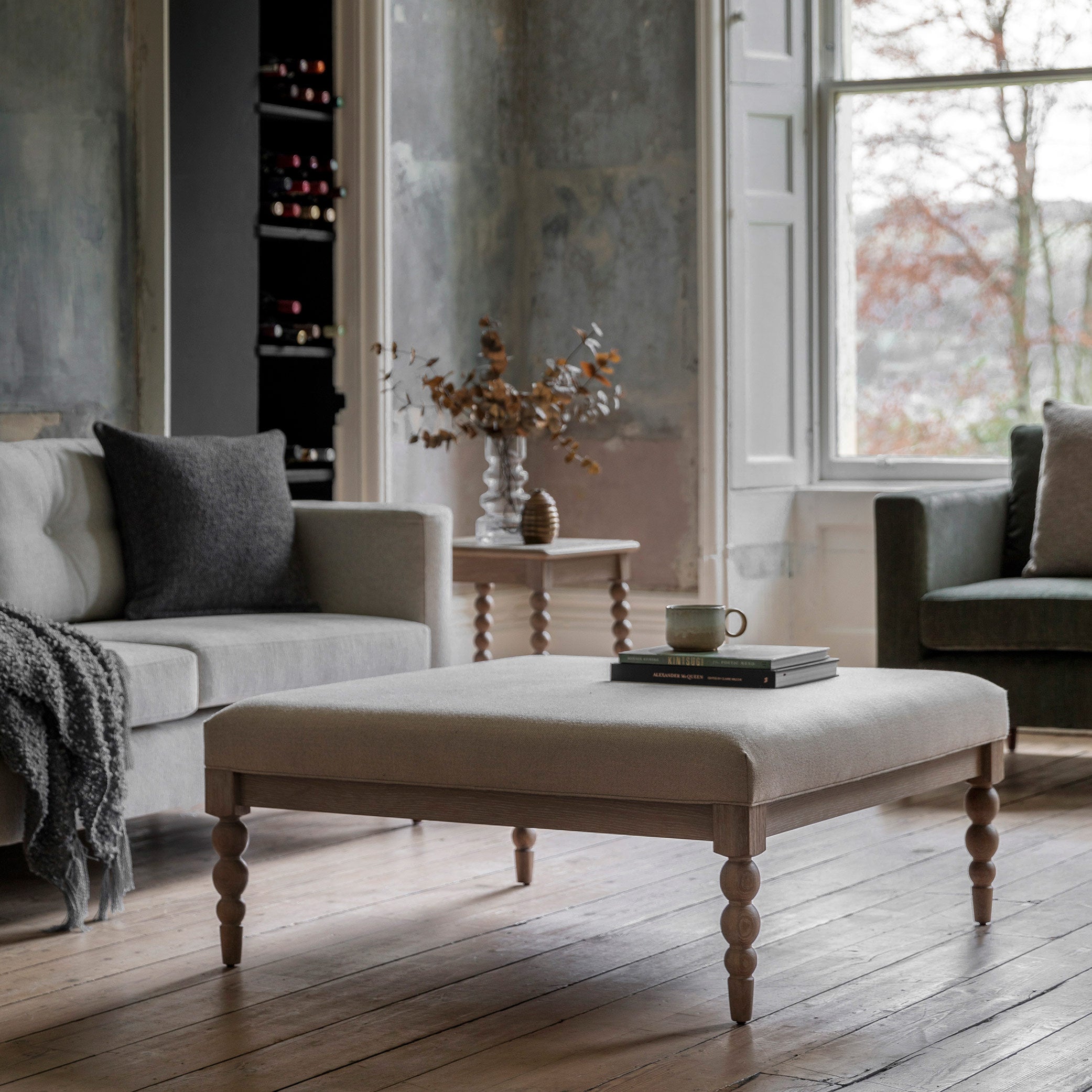 Oak coffee table in lime wash finish, handcrafted bobbing detailed legs and upholstered neutral fabric top