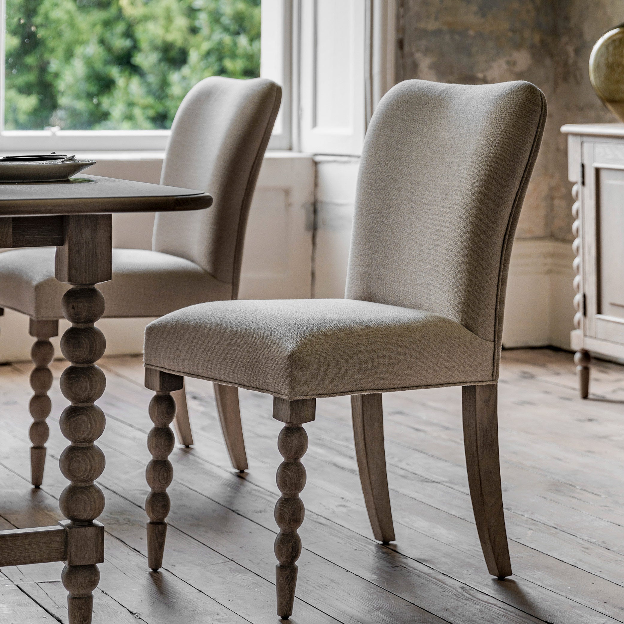 Oak dining chair in lime wash finish, handrafted bobbing detailed legs and upholstered neutral fabric seat