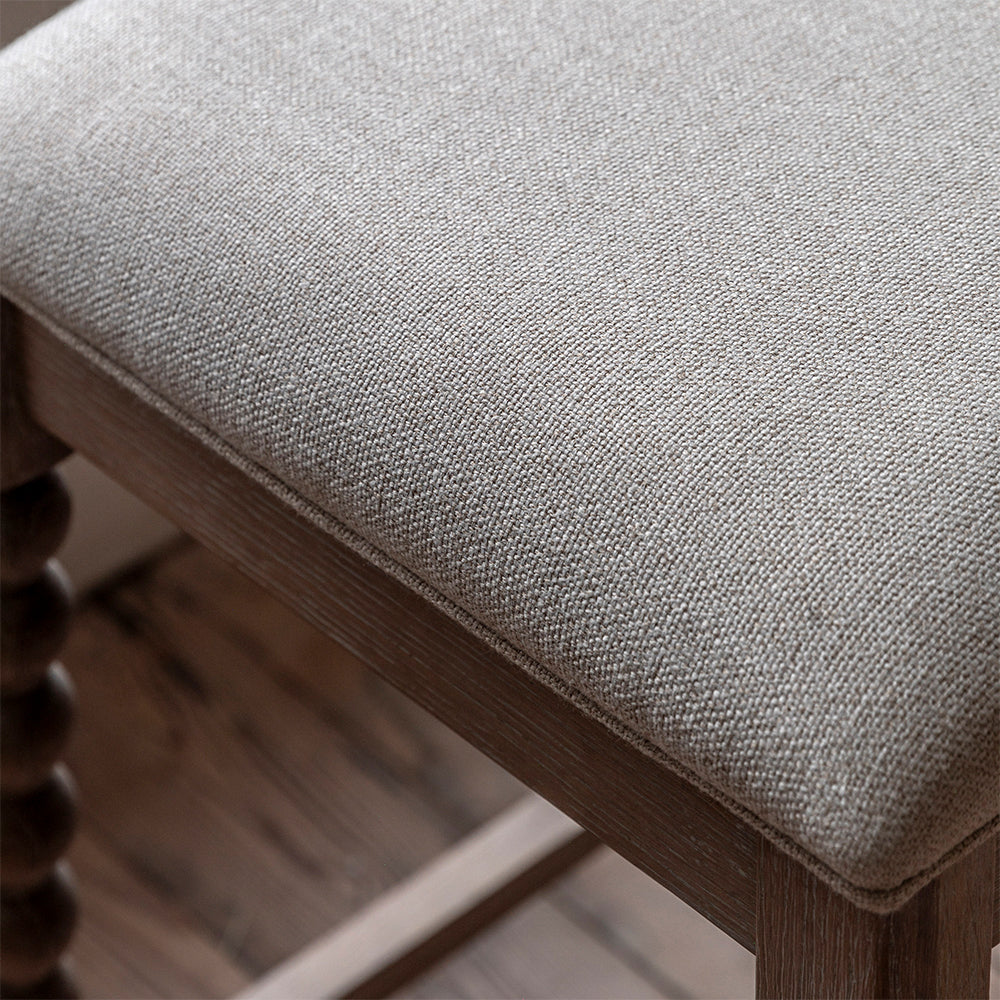 Oak small barstool in lime wash finish, handcrafted bobbing detailed legs and upholstered neutral fabric seat