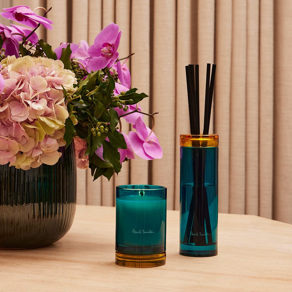 Paul Smith Sunseeker Diffuser housed in tinted turquoise glass vessel and contrasting collar with black diffuser reeds