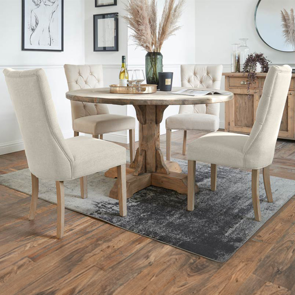 Upholstered dining chair in neutral fabric with studded back and wooden legs