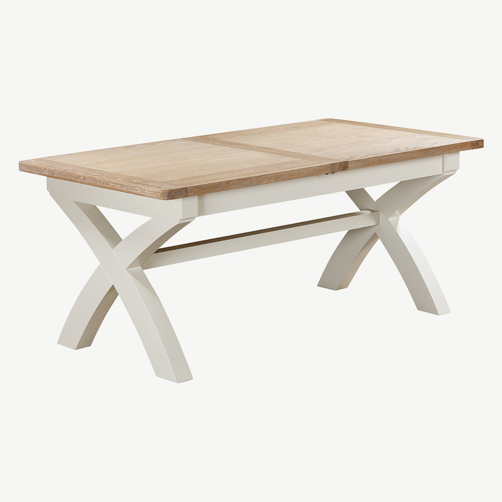 Extending rectangular dining table with natural wood top and painted off-white cross legs
