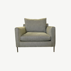 Light grey armchair in upholstered fabric with leather micro piping on arm fronts