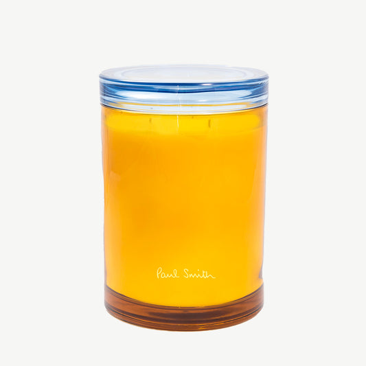 Paul Smith Daydreamer Scented Candle housed in tinted yellow glass vessel and contrasting collar that doubles as a coaster