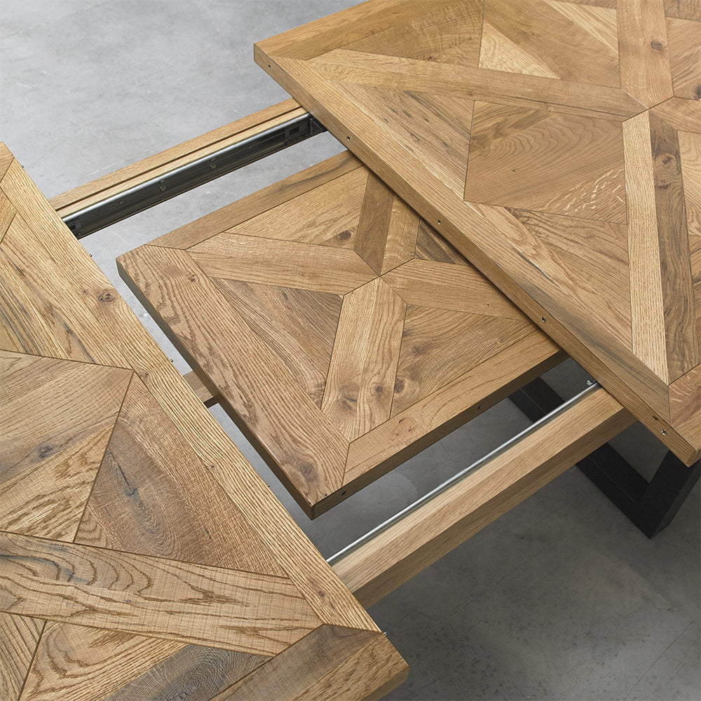Oak veneer extending dining table with black powder coated metal base
