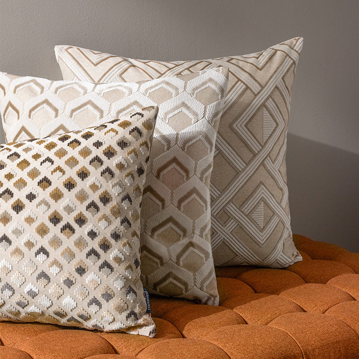 Rectangular scatter cushion featuring raised chequered design in varying hues of brown, white and gold with reverse plain side