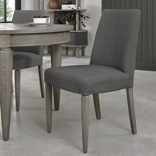 Slate grey upholstered fabric chair with tapered silver grey wooden legs 