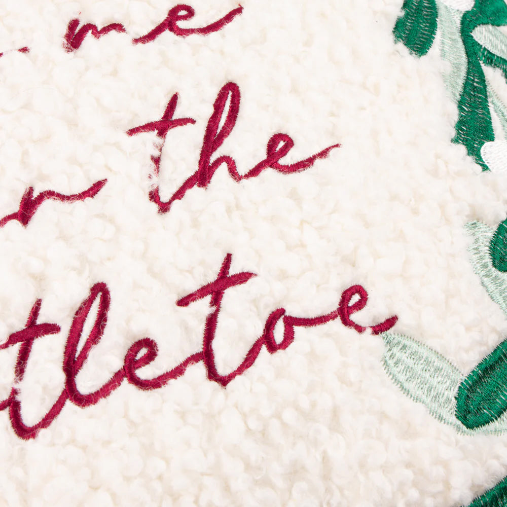 Decorative Christmas pillow with 'kiss me under the mistletoe' text