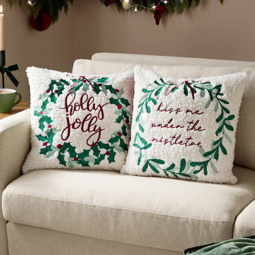 Decorative Christmas pillow with 'kiss me under the mistletoe' text