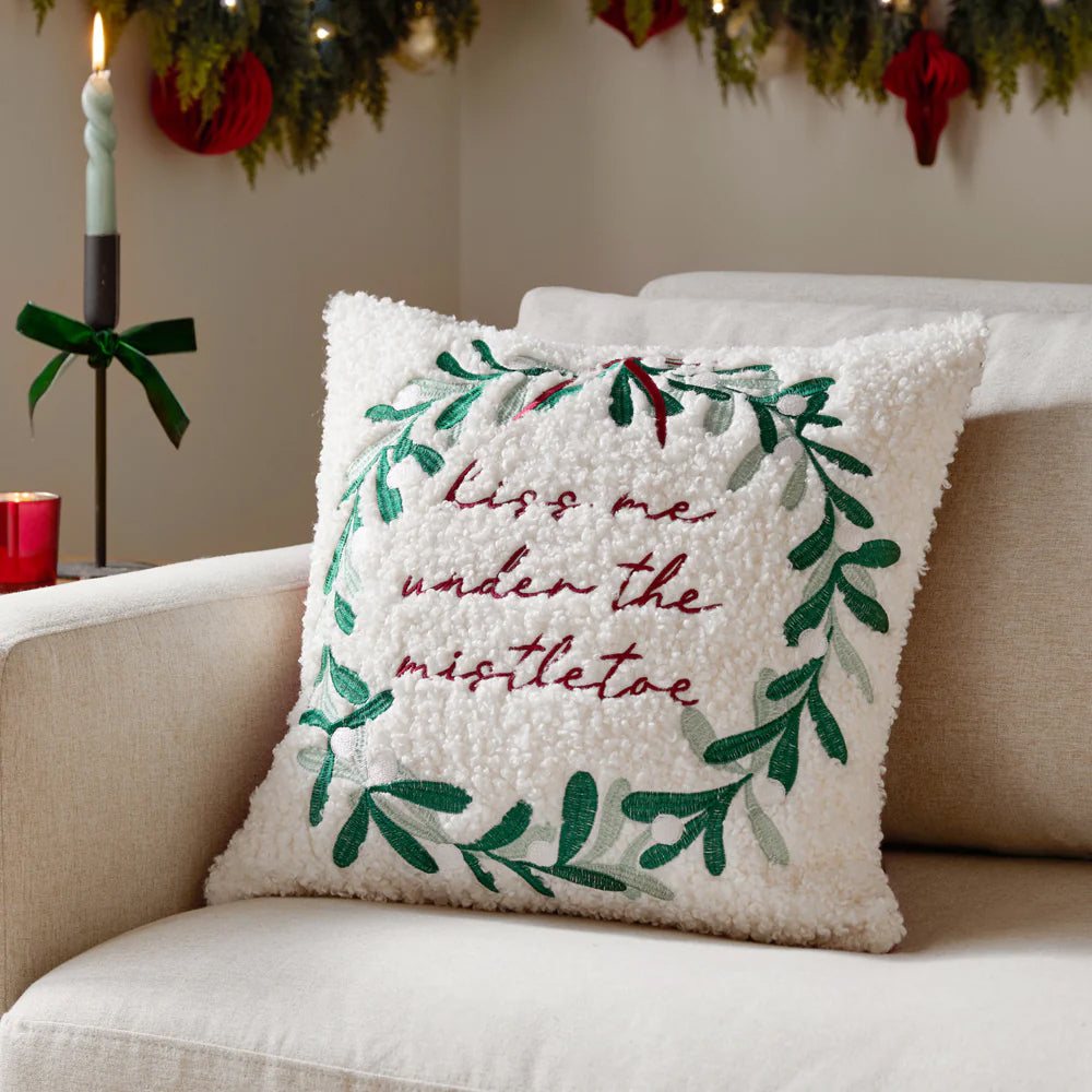 Decorative Christmas pillow with 'kiss me under the mistletoe' text