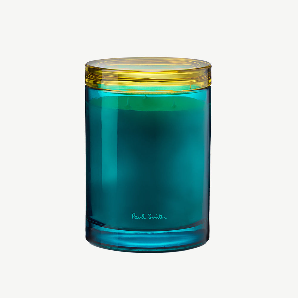Paul Smith Sunseeker Scented Candle housed in tinted turqoise glass vessel and contrasting collar that doubles as a coaster