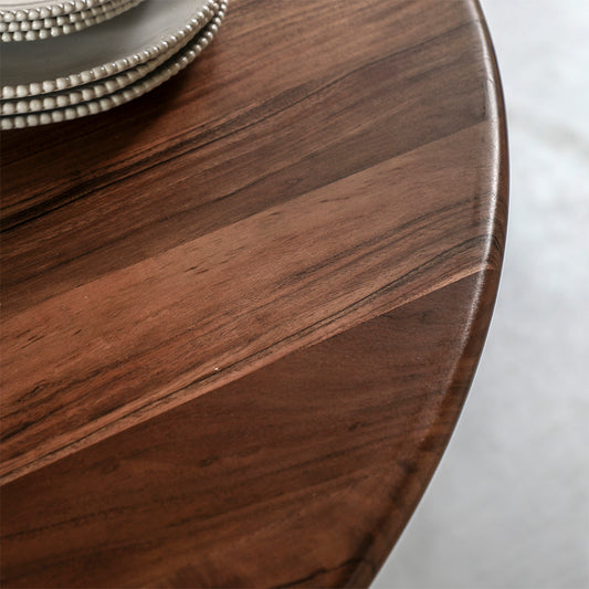 Acacia wood round dining table in natural finish with wide angled legs