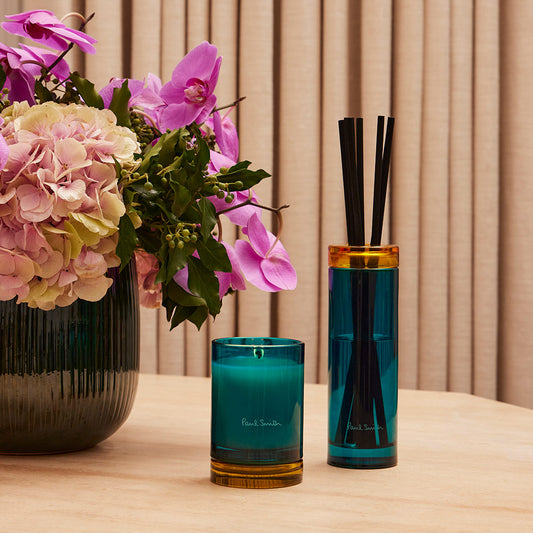 Paul Smith Sunseeker Diffuser housed in tinted turquoise glass vessel and contrasting collar with black diffuser reeds