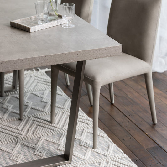 Solid stone effect grey toned rectangular dining table set upon modern angular legs
