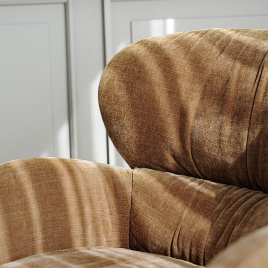 Sits ross chair boasting tapered wooden legs and soft brown upholstery, creating a warm and inviting atmosphere