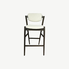 Counter stool featuring upholstered padded seat and back cushions. Neutral light colour of the upholstery complements the dark wood frame and legs