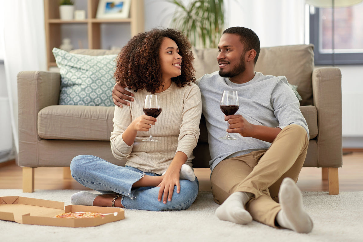 couple enjoying wine and pizza
