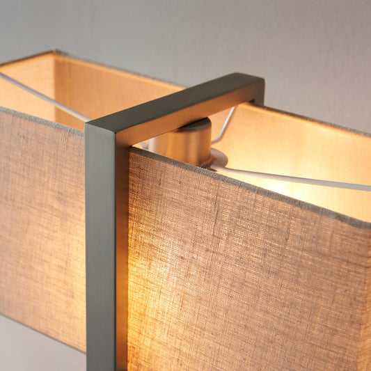 Modern table lamp with matt black base, satin nickel finished frame and linen shade