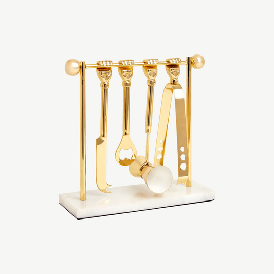 Brass bartools attached to solid brass dumbell, placed on a white marble base