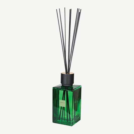 Emerald green glass diffuser with contrasting black lid and matching reeds