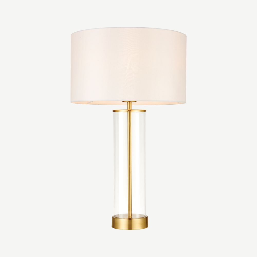 Simple  table light with a clear glass base, vintage white faux silk shade and a brushed gold effect finish
